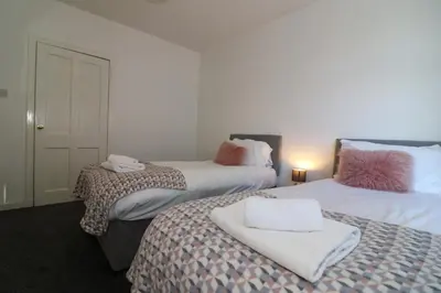 a room with two beds with towels on them at Signature - Anderson View in Motherwell