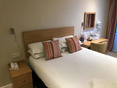 a bedroom with a large white bed with two pillows at Selborne Hotel in Dunoon