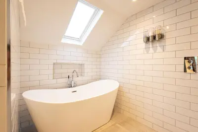 a white bath tub in a bathroom with a window at Altskeith Country House in Aberfoyle