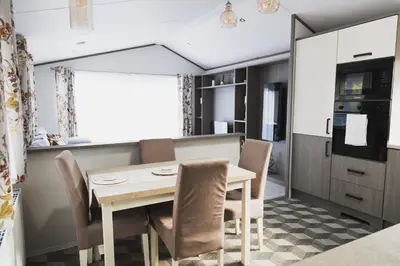 a kitchen and dining room with a table and chairs at Atlas Ovation Lodge in Auchterarder