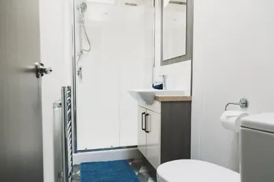 a bathroom with a shower and a toilet and a sink at Atlas Ovation Lodge in Auchterarder