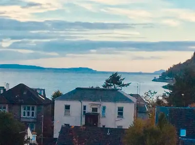 a white house with a view of the water at DUNOON - TOWN CENTRE HOLIDAY HOME APARTMENT in Dunoon