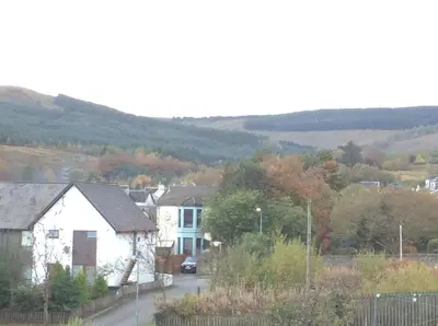 a small town with houses and trees and hills at DUNOON - TOWN CENTRE HOLIDAY HOME APARTMENT in Dunoon