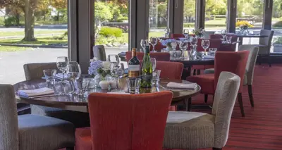 a dining room with tables and chairs with wine bottles at Best Western The Hilcroft Hotel West Lothian in Whitburn