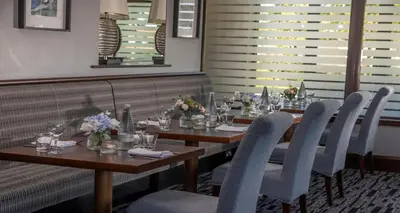 a dining room with two tables and chairs with flowers at Best Western The Hilcroft Hotel West Lothian in Whitburn
