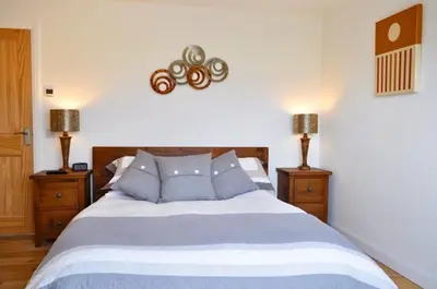 a bedroom with a large bed with blue pillows at Lurach House in Port Appin