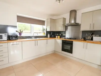 a kitchen with white cabinets and a stove top oven at Lurach House in Port Appin