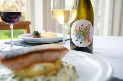 a white plate with a bottle of wine and a glass at Mansewood Country House in Lochearnhead