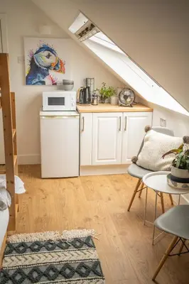 a kitchen with white cabinets and a counter top at Forty Winks Loch Lomond in Balloch