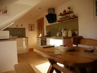 a kitchen with a wooden table with a bowl of fruit on it at Cameron Cottage in Inverkip