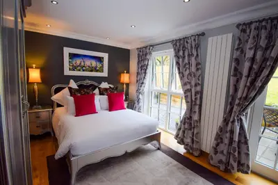 a bedroom with a bed with red pillows and a window at Outlander Glencoe at Creag an-t Sionnaich Glencoe Ballachulish Highlands Near Fort William in Glencoe