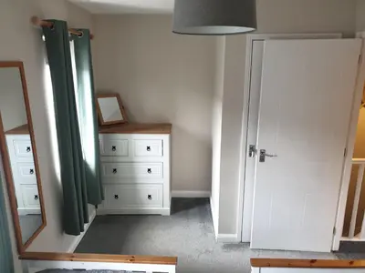 a room with a mirror and a white door at Oldwood Place Townhouse in Livingston