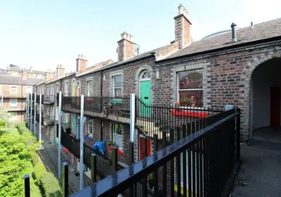 a brick house with a black fence and a building at Stylish Flat in 1860's Listed Building in Edinburgh