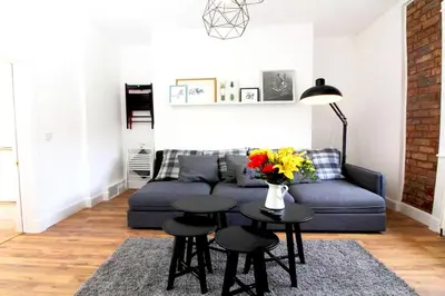 a living room with a couch and a table with flowers at Stylish Flat in 1860's Listed Building in Edinburgh