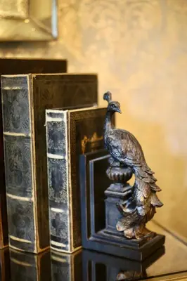 a bronze statue of a peacock standing next to a book at Cairn Lodge in Auchterarder
