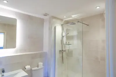 a bathroom with a shower and a toilet and a sink at Duck Bay Hotel & Restaurant in Balloch