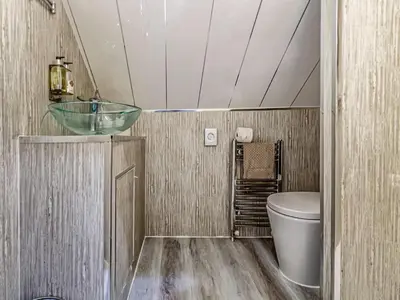 a bathroom with a toilet and a glass sink at The Golden Crown in Tarbolton