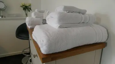 a pile of towels sitting on top of a counter at Riverside Apartments in Carluke