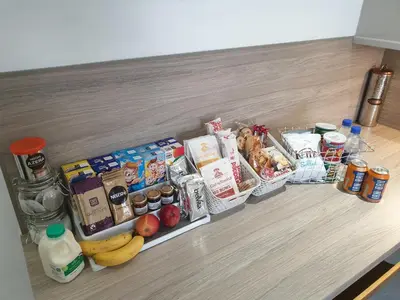 a kitchen counter with various food items and drinks at Riverside Apartments in Carluke
