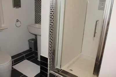 a bathroom with a shower and a toilet and a sink at Nelson Seaside Apartment in Largs