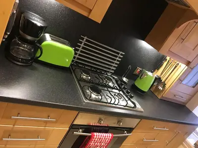 a kitchen with a stove and a green appliance at Nelson Seaside Apartment in Largs