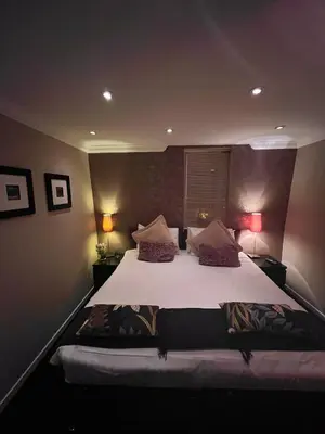 a bedroom with a large bed with white sheets and pillows at Gleneagles Lettings in Auchterarder