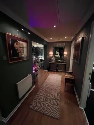 a room with a hallway with a table and a rug at Gleneagles Lettings in Auchterarder