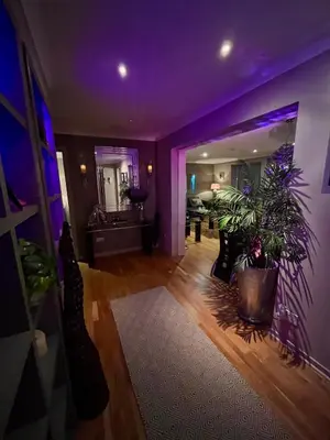 an empty living room with purple lighting and plants at Gleneagles Lettings in Auchterarder