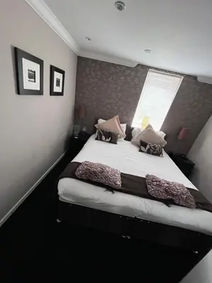 a bedroom with a large bed with a window at Gleneagles Lettings in Auchterarder