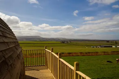 a wooden deck with a view of a green field at Mains Farm in Stirling