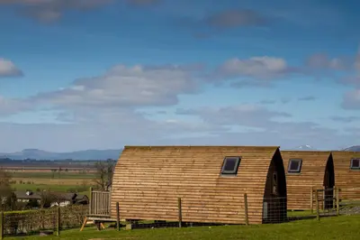 a large wooden barn with a bench next to it at Mains Farm in Stirling