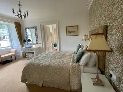 a bedroom with a bed and a table with a lamp at Thistle House Guest House in Saint Catherines