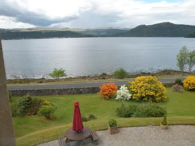 a garden with a table and a view of a lake at Thistle House Guest House in Saint Catherines