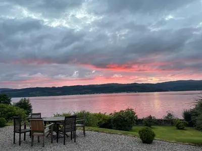 a table and chairs with a view of a lake at Thistle House Guest House in Saint Catherines