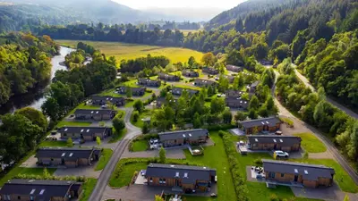 an aerial view of a village in the mountains at Balloch Park in Aberfeldy