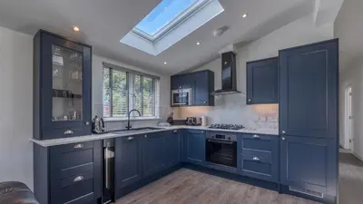 a kitchen with blue cabinets and a skylight at Balloch Park in Aberfeldy