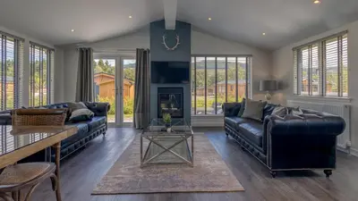 a living room with a couch and a fireplace at Balloch Park in Aberfeldy