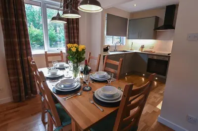 a kitchen and dining room with a table and chairs at Birchbrae Highland Lodges in Onich