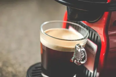 a cup of coffee in a coffee machine at PREMIER SUITES PLUS Glasgow George Square in Glasgow