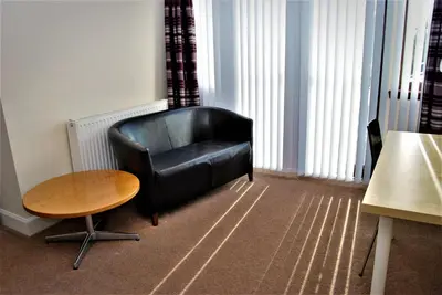 a black leather chair and a table in a room at The Old Schoolhouse Hotel in Larkhall