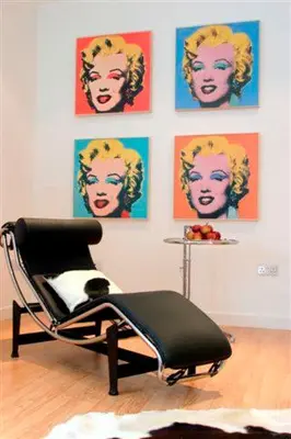 a chair in a room with posters on the wall at River Clyde West End Apartment - 2 Bedrooms in Glasgow