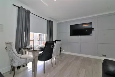 a dining room with a table and chairs and a television at 2 Bedroom Apartment at SECC Hydro FREE PARKING in Glasgow
