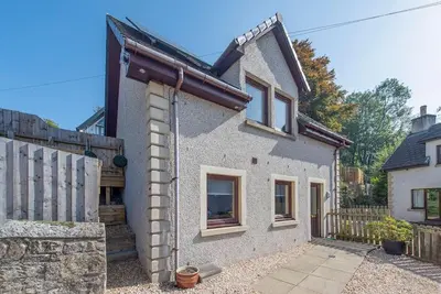 a brick house with a gate and a fence at Wallace's Rest in Stirling