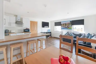 a kitchen and living room with a table and chairs at Wallace's Rest in Stirling