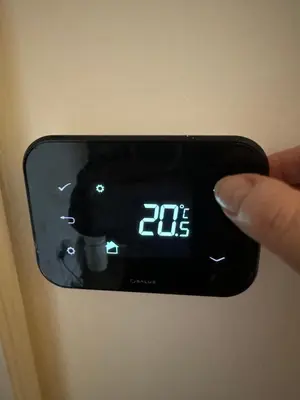 a person holding an alarm clock in their hand at Stunning 2 bedroom apartment in Glasgow