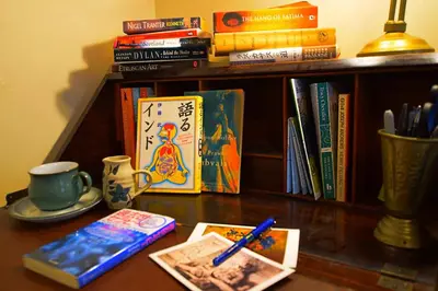 a table with books and a cup of coffee and a book shelf at JOIVY Bohemian Writers Retreat in Old Town in Edinburgh
