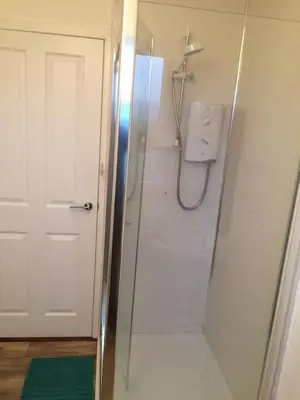 a shower in a bathroom with a glass door at Ardminish House Gigha in Isle of Gigha