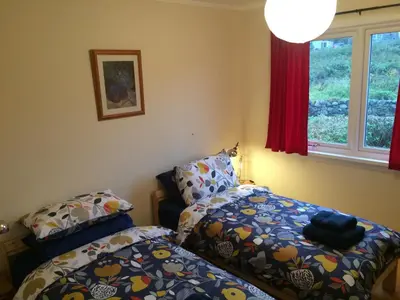 a bedroom with two beds and a window at Ardminish House Gigha in Isle of Gigha