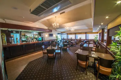 a restaurant with tables and chairs and a bar at The Burnside Hotel in Glasgow
