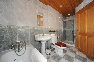 a bathroom with a toilet and a sink and a tub at Craigard House Hotel in Campbeltown